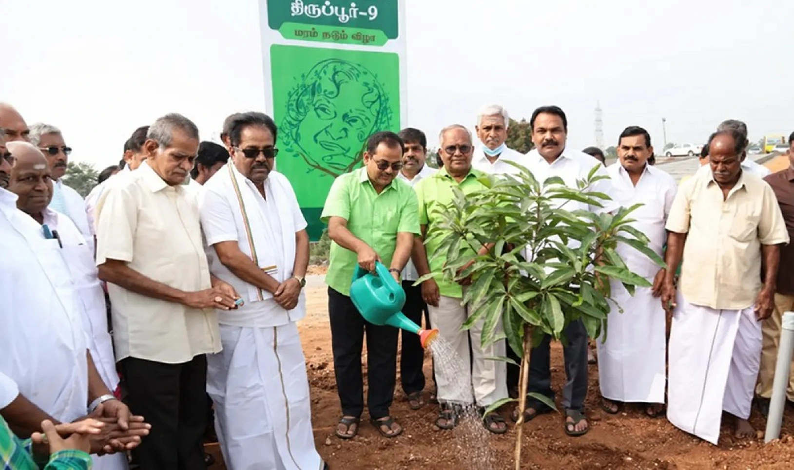 Watering a newly planted sapling at a community planting
